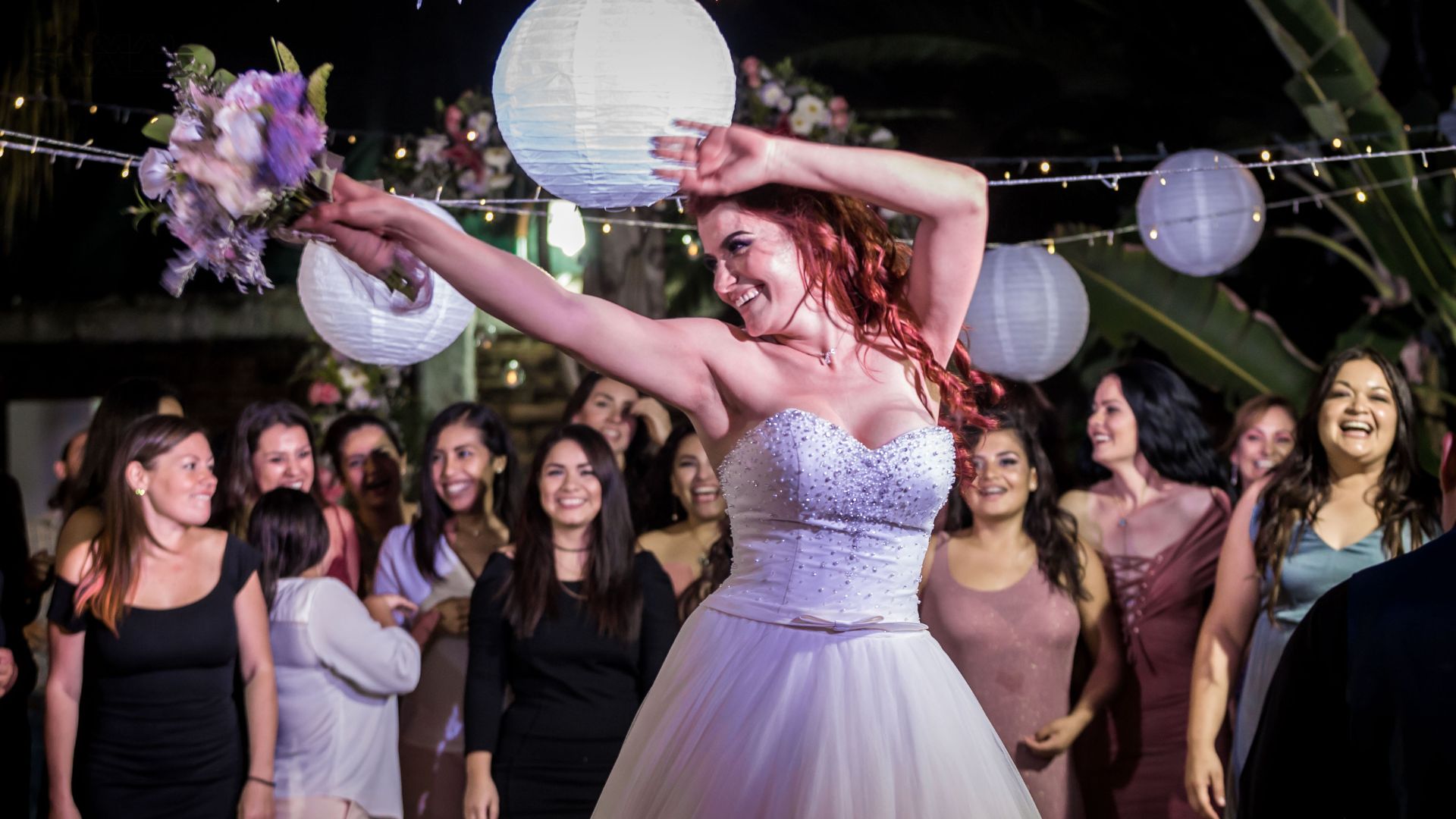 Bouquet toss moment at a Chicago wedding DJ reception with guests reaching up